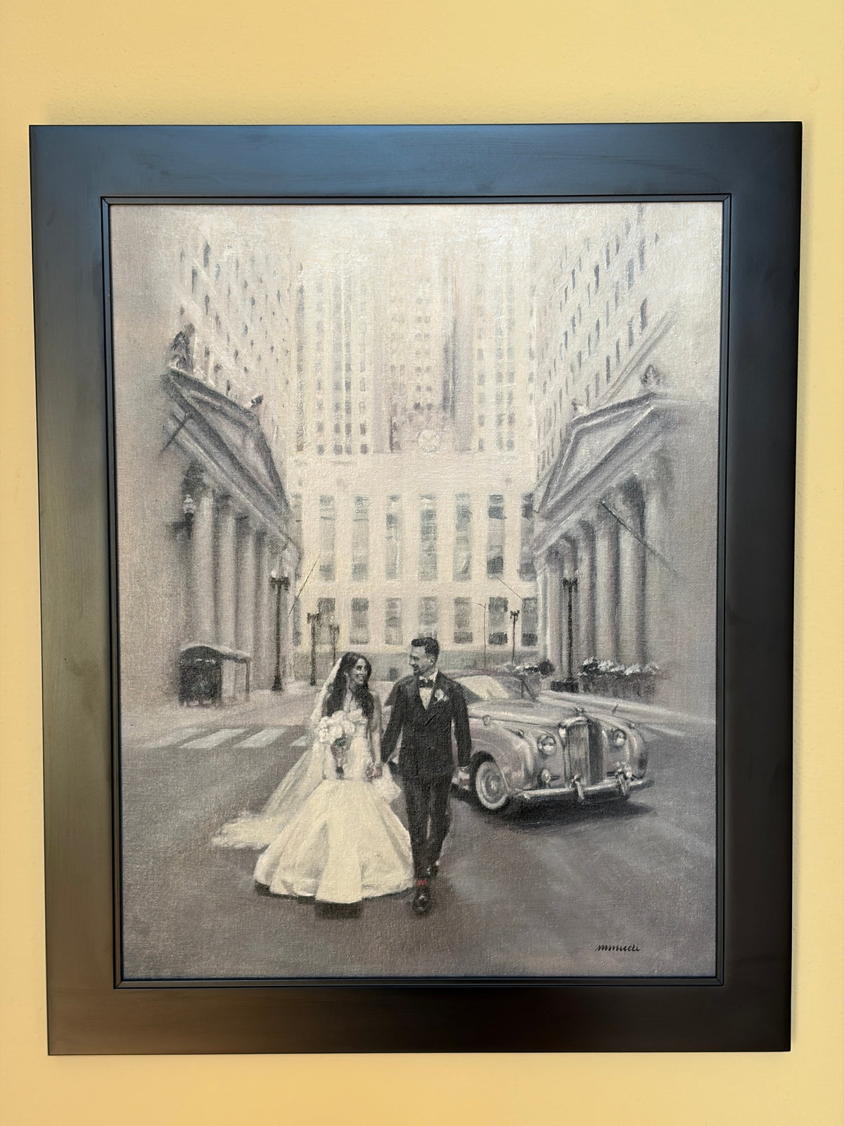 A framed black and white oil painting depicting a bride and groom walking down a city street with a classic car